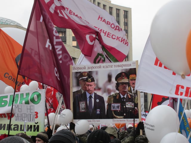 Moscow rally in Sakharov Avenue, the top text says "You are on the right way, comrades!" while the bottom text marks "Colonel Putin and Colonel Gaddafi", 24 December 2011