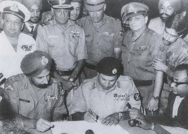 Lt-Gen. Niazi, Cdr. of Eastern Command of Pakistan Army and Governor of East Pakistan, signing the documented instrument with Lt Gen. JS Aurora, GOC-in-C of Eastern Command in India, in presence of Indian army personnel in Dacca, unilaterally ending the conflict with India on 16 December 1971.