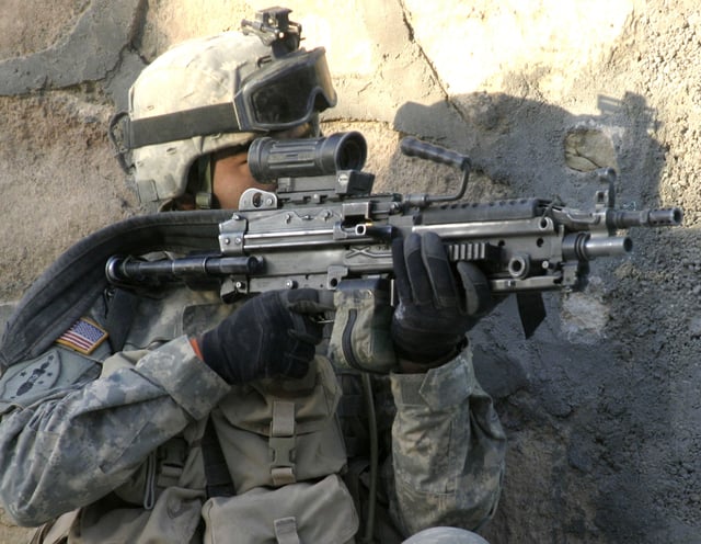 A soldier from the 1st Infantry Regiment provides security for a joint Army-Marine patrol in Rawa in 2006. The shoulder sleeve insignia has the logo of the 2nd Marine Division.