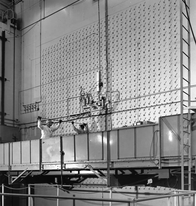 Workers load uranium slugs into the X-10 Graphite Reactor.