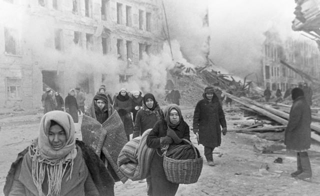 Soviet civilians leaving destroyed houses after a German bombardment during the Battle of Leningrad, 10 December 1942