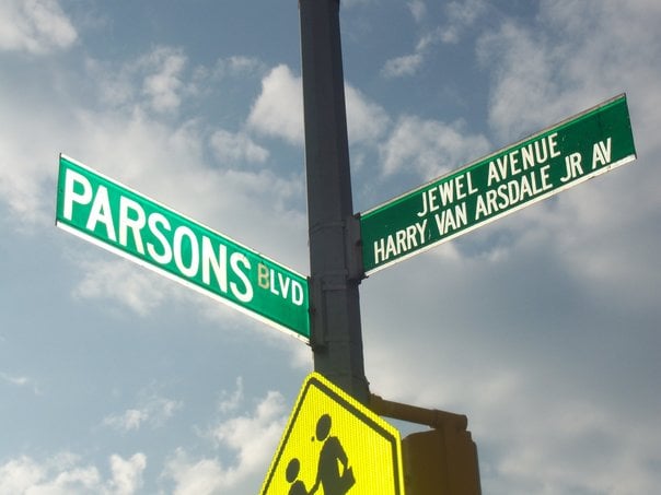 Standard cross-street signs for a single-named Boulevard and a co-named Avenue, in Queens