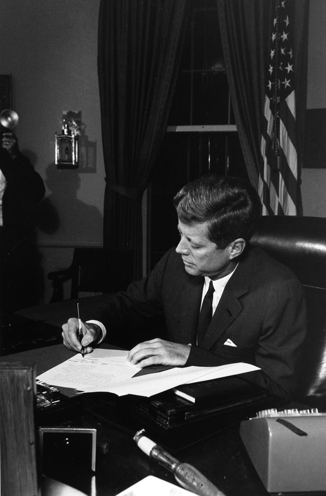 President Kennedy signs the Proclamation for Interdiction of the Delivery of Offensive Weapons to Cuba at the Oval Office on October 23, 1962.