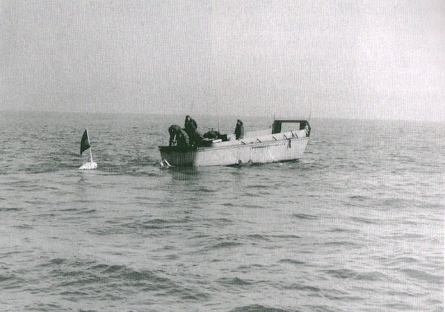 U.S. Navy sailors stream minesweeping gear behind an LCVP off Chinnampo, North Korea, on 5 December 1950 during the Korean War.