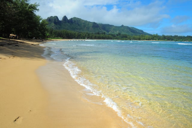 Anahola Bay is a snorkeling and swimming beach with clear pools and a long coral reef. Driving directions in the Kauai Trailblazer guide.