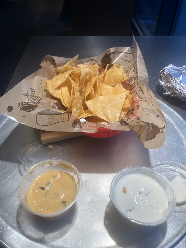 Chipotle regular sized chips and queso with a side of sour cream.