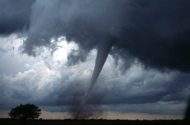 A tornado near Anadarko, Oklahoma, 1999. The funnel is the thin tube reaching from the cloud to the ground. The lower part of this tornado is surrounded by a translucent dust cloud, kicked up by the tornado's strong winds at the surface. The wind of the tornado has a much wider radius than the funnel itself.