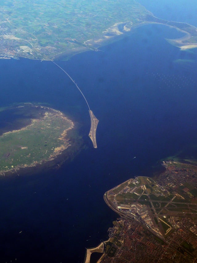 Aerial photo of Øresund Bridge. In the foreground is Copenhagen Airport on the island of Amager, to the left of the bridge is the Danish island of Saltholm, and in the background, the bridge connects to Malmö.