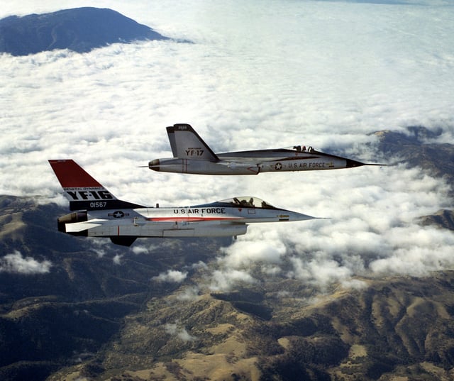 A right-side view of a YF-16 (foreground) and a Northrop YF-17, each armed with AIM-9 Sidewinder missiles