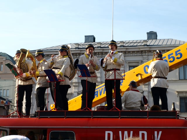 The Retuperä WBK is a student band that parodies a volunteer fire brigade brass band. In this picture Retuperä is performing in central Helsinki on top of their fire truck.