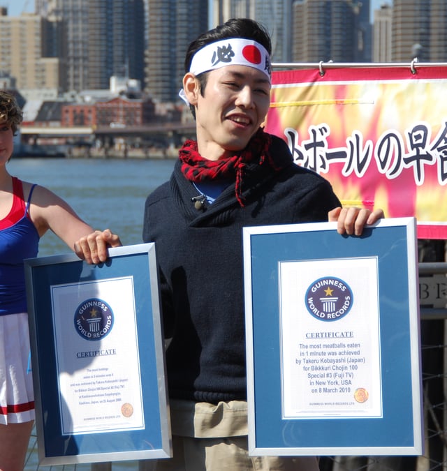 Japanese competitive eater Takeru Kobayashi with two Guinness World Record certificates