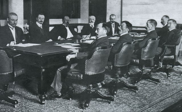 Negotiating the Treaty of Portsmouth (1905). From left to right: the Russians at far side of table are Korostovetz, Nabokov, Witte, Rosen, Plancon; and the Japanese at near side of table are Adachi, Ochiai, Komura, Takahira, Satō. The large conference table is today preserved at the Museum Meiji-mura in Inuyama, Aichi Prefecture, Japan.