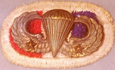 Parachutist Badge of a World War II veteran from the 506th Infantry Regiment—as indicated by the background trimming—who made two combat jumps—as denoted by the two Combat Jump Devices on the badge