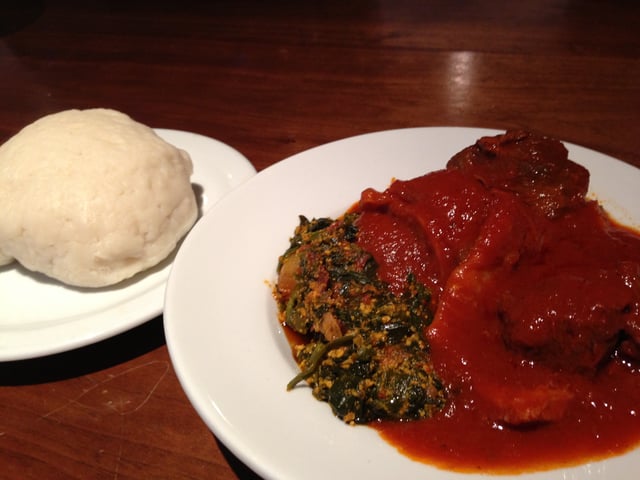 A plate of pounded yam (iyan) and egusi soup with tomato stew.
