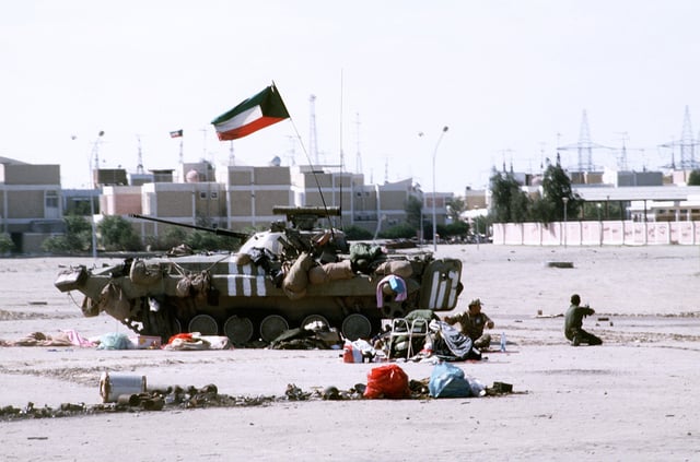 Kuwaiti soldiers sit beside a Kuwaiti BMP-2 infantry fighting vehicle during Operation Desert Storm.