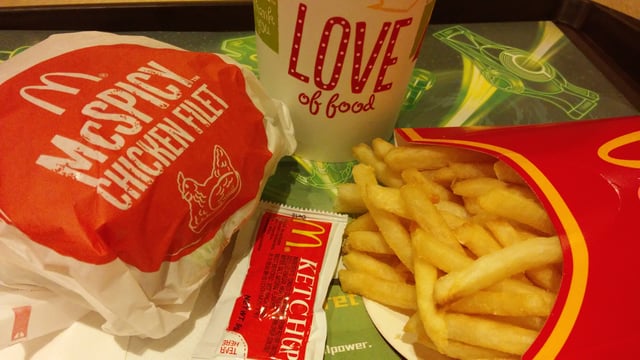 A typical "eat-in" McDonald's meal as sold in Hong Kong, consisting of French fries, a soft drink, and a "main product" – in this case, a McSpicy Chicken Fillet. Condiments are supplied in small packets; such a packet of tomato ketchup is seen in the foreground.