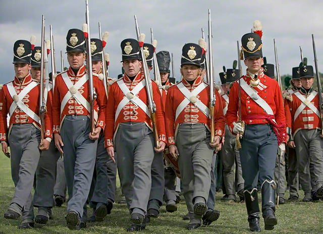 Reenactors in the red-coated uniform of the 33rd Regiment of Foot as worn during the Napoleonic Wars between 1812 and 1816. Note the brighter scarlet of the officer on the right.