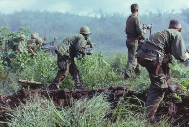 A U.S. Army infantry patrol moves up to assault the last North Vietnamese Army position at Dak To, South Vietnam during Operation Hawthorne