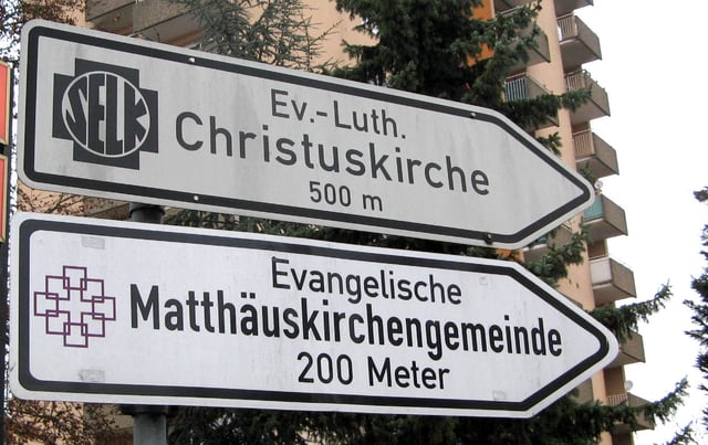 Direction signs showing ways to two different Protestant churches in the German city of Wiesbaden.