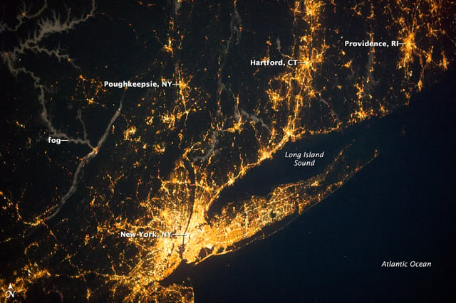 Satellite imagery showing the New York metropolitan area at night. Long Island is highly developed and densely populated, extending approximately 120 miles eastward from the central core of Manhattan.