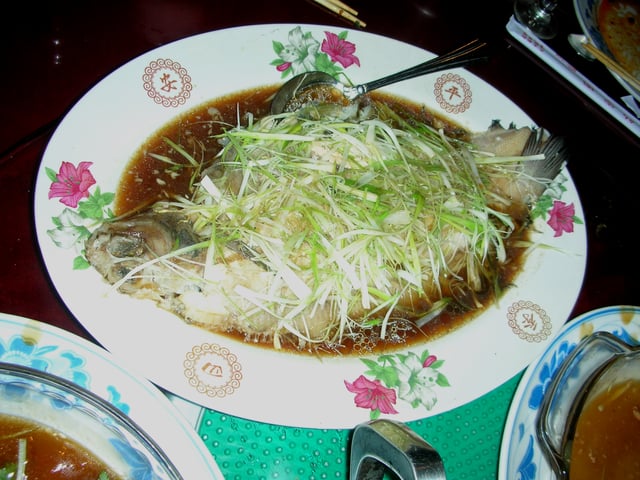 Steamed whole perch with roe inside. Sliced ginger and spring onion is usually spread on top.