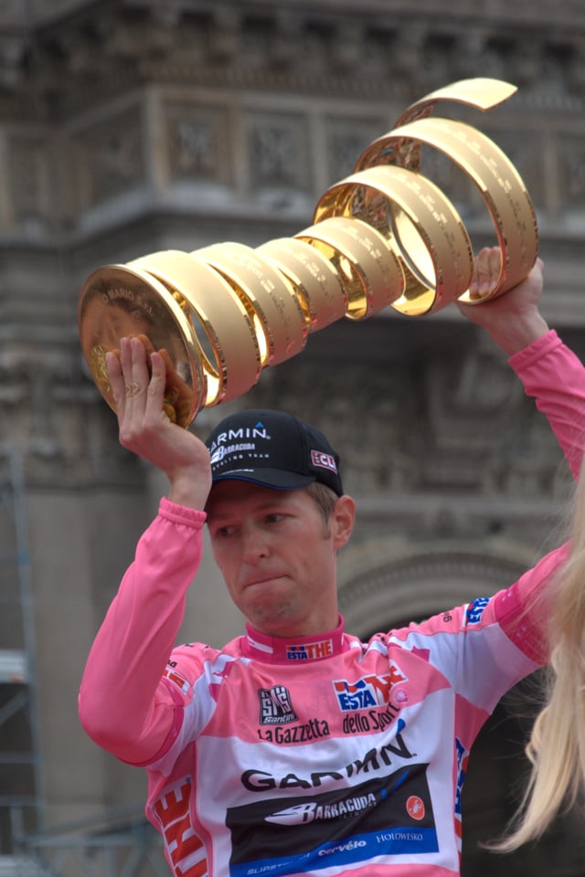 Ryder Hesjedal, the winner of the 2012 Giro d'Italia, wearing the maglia rosa and holding the winner's trophy in Milan.