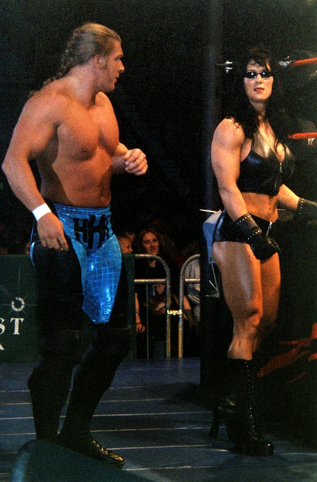 Chyna (right), acted as an enforcer for Triple H (left) and Michaels in 1997, then remained allied with the larger incarnation of the stable until 1999