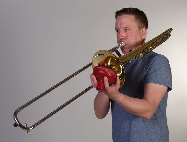 A trombonist using a plunger mute