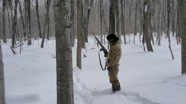 A U.S.B.P. agent tracking someone in harsh winter conditions on the northern border.