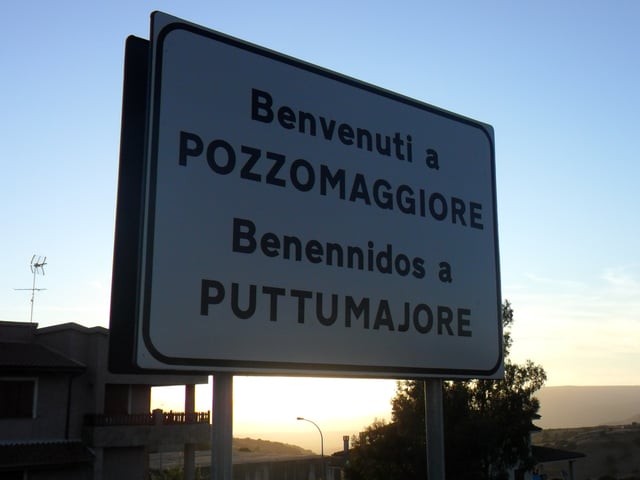 A bilingual road sign in Italian and Sardinian at Pozzomaggiore.