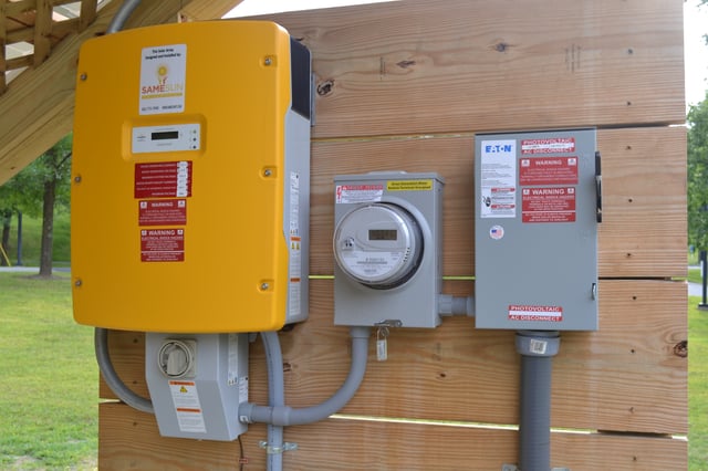 String inverter (left), generation meter, and AC disconnect (right). A modern 2013 installation in Vermont, United States.
