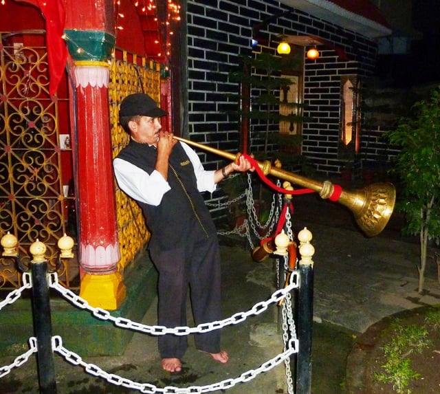 Playing trumpet at Palace Temple. Mandi, Himachal Pradesh, India