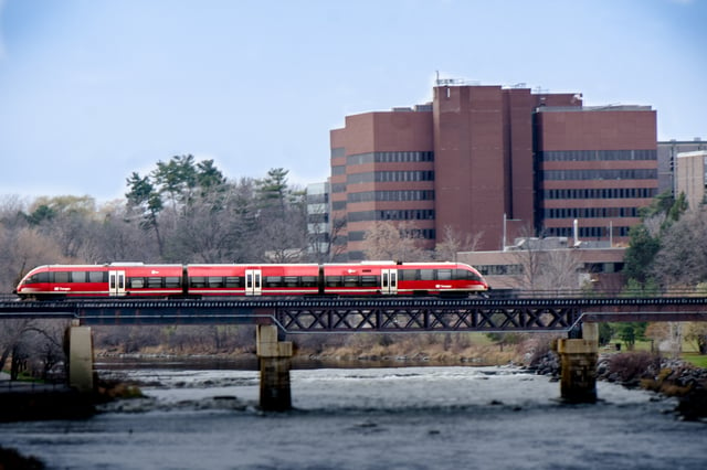 An O-Train crossing the Rideau River. The O-Train is a light rail public transportation service provided by OC Transpo.