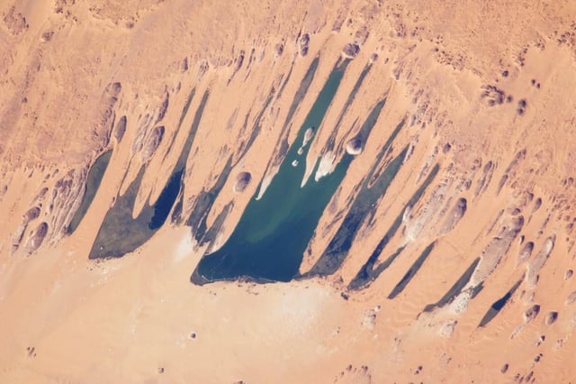 This astronaut photograph features one of the largest of a series of ten mostly fresh water lakes in the Ounianga Basin in the heart of the Sahara Desert of northeastern Chad.