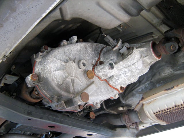 Center transfer case sending power from the transmission to the rear axle (right) and front axle (left)
