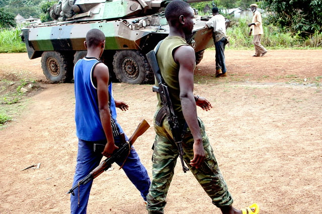 Armed Ivorians next to a French Foreign Legion armoured car, 2004