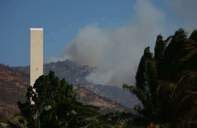 Smoke billows on a hill near the Phillips Theme Tower