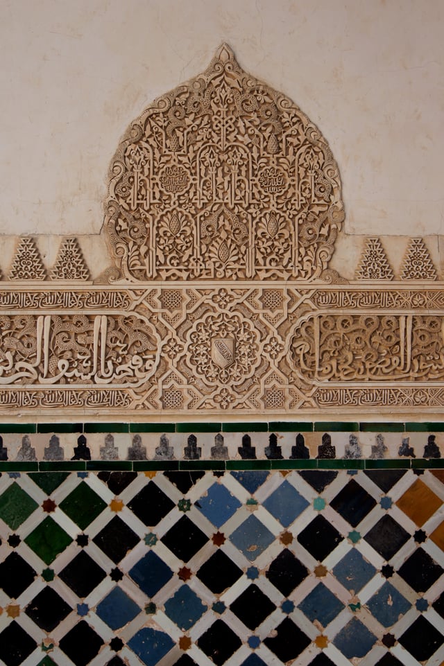Mosaic and arabesque on a wall of the Myrtle court in Alhambra, Granada.