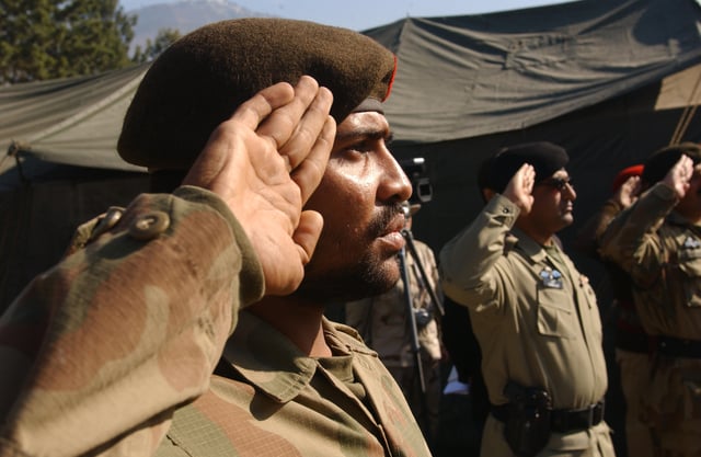 Pakistan army soldiers saluting British-style, palms facing outward.