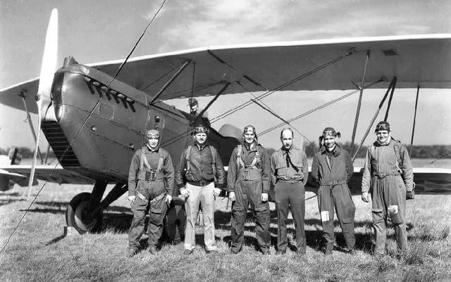 A 10/20/30 photo of MD National Guard 104th Observation Squadron pilots in front of one of the unit's O-11 Falcons at the unit's home station, Logan Field.