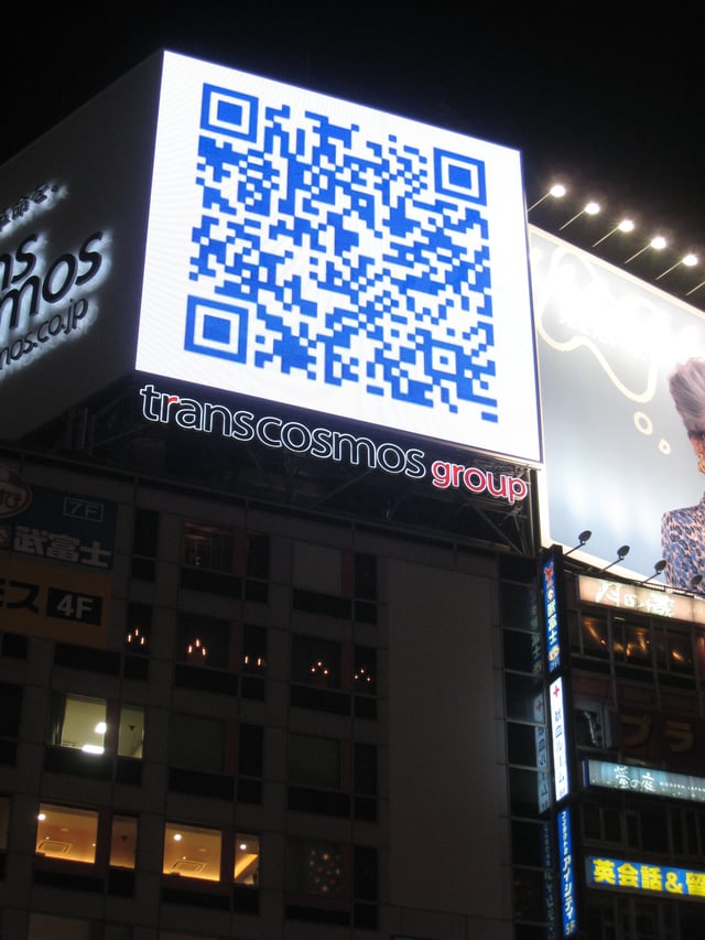 A QR code used on a large billboard in Japan, linking to the sagasou.mobi website
