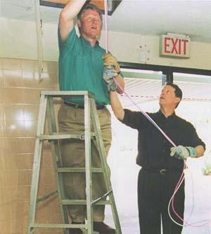 President Bill Clinton installing computer cables with Vice President Al Gore on NetDay at Ygnacio Valley High School in Concord, CA. March 9, 1996