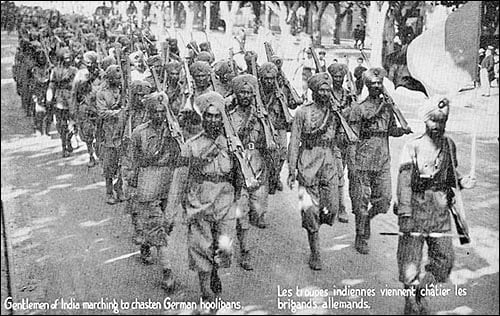 French postcard depicting the arrival of the 15th Sikh Regiment in France during World War I; the bilingual postcard reads, "Gentlemen of India marching to chasten the German hooligans".