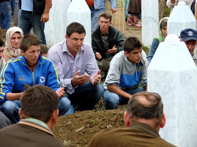 Mourners at the reburial ceremony for an exhumed victim of the Srebrenica massacre