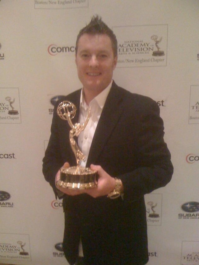 New England sports personality Charlie Moore holding a New England Emmy Award in 2011