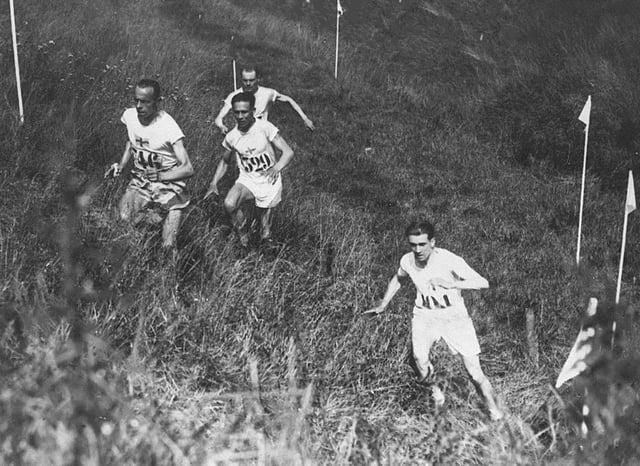 Individual cross country race at the 1924 Summer Olympics in Paris, France. The left trio is Edvin Wide, Ville Ritola and Paavo Nurmi. Due to the hot weather (over 40 °C (104 °F)) only 15 out of 38 competitors (elite long-distance runners) could finish the race.