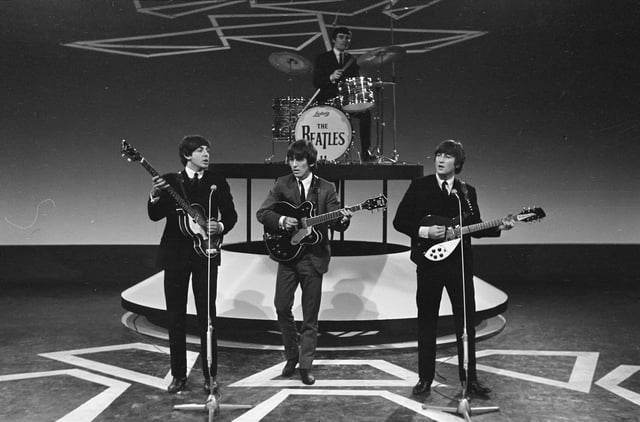 Lennon (right) performing in 1964 at the height of Beatlemania