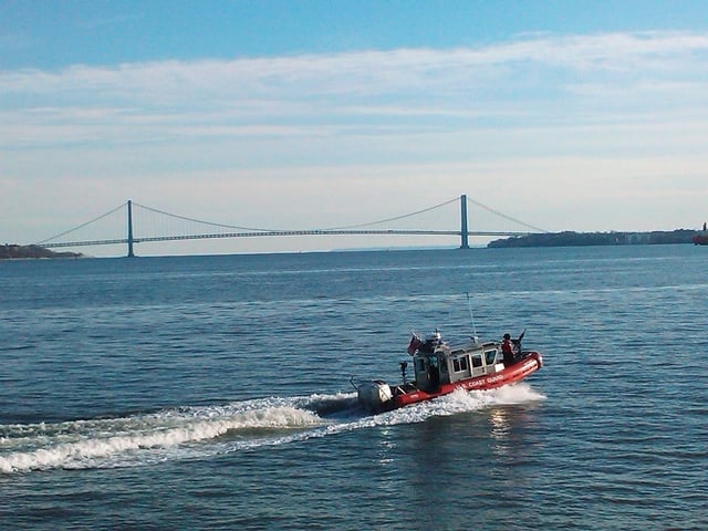 United States Coast Guards on counterterrorism patrol in Upper New York Bay. Verrazano-Narrows Bridge in distance spanning The Narrows between Brooklyn (left) and Staten Island (right).