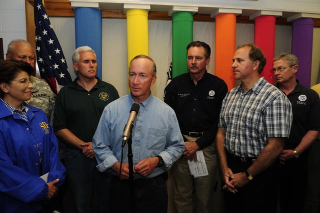 Then-U.S. representative Pence (third from left) standing behind then-governor Mitch Daniels at a 2008 press conference in Martinsville, Indiana