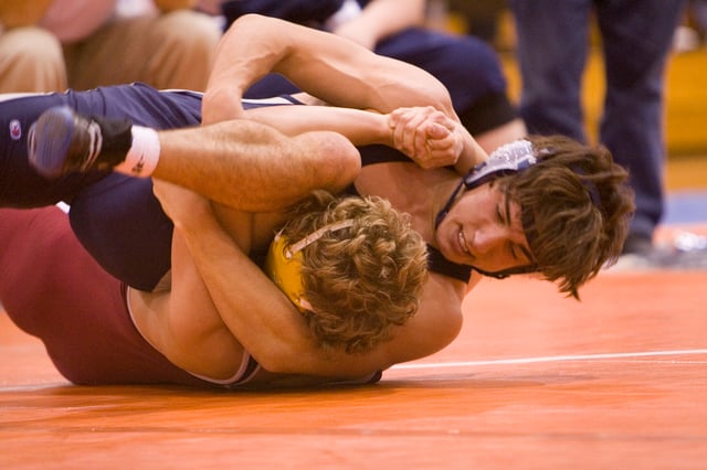 Two high school students competing in scholastic wrestling (collegiate wrestling done at the high school and middle school level)